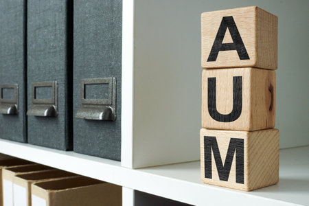 AUM Assets Under Management blocks on an office shelf symbolizing investment management.の写真素材