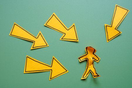 Workplace bullying or social pressure. Arrows pointing at crumpled figure.の写真素材