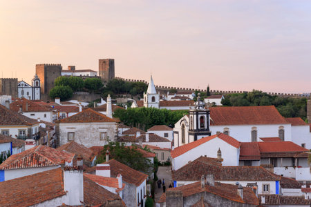 Scenic view of white houses red tiled roofs. and castle of Obidos from wall of fortress. Beautiful...