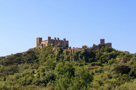 Beautiful view of the fortress. The ancient castle and wall of Obidos, Portugal. Castelo de Obidos. One of the most popular tourist destinations. Summer sunny day.のeditorial素材