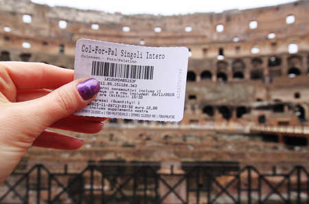 Rome, Italy â November 26, 2015. Girl holding a ticket on the blurred background of interior of Colosseum. Soft focus travel photography.の写真素材
