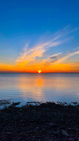 Bright sunset with yellow sun under water surface. Tranquil sunset over the sea. Summer evening....