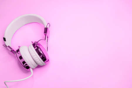 Music design with purple headphones on pink colored background. An empty space for the text.の写真素材