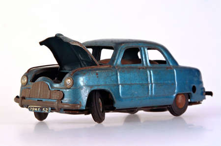 A battered and broken tin toy car, with bonnet open.の写真素材