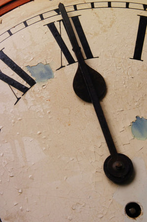 Close up of the hands of an old clock striking midnight.