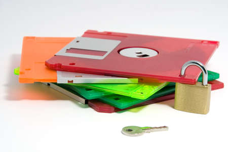 A pile of coloured floppy discs, secured with a padlock. Isolated on a white background.の写真素材