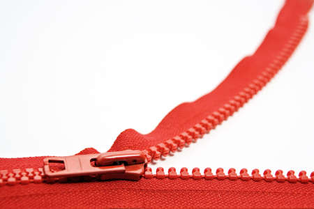 Photo of an open red zipper on a white background, narrow depth of field.の写真素材