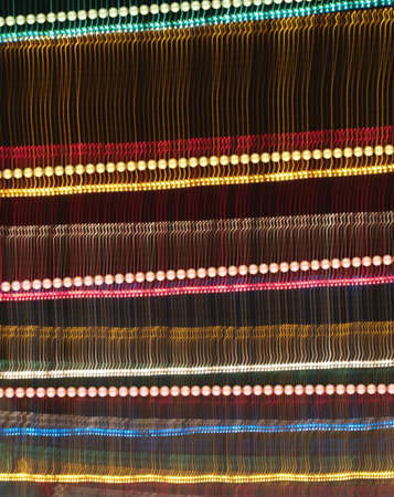 Motion blur effect from party lights in front of a black night sky, with an added layer of detailed, shining lamps on it                               の写真素材
