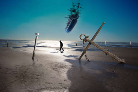 anchor on a coastline with low ebb, and water level poles and a silhouette of walking person, waiting for a flying ship to arriveの写真素材