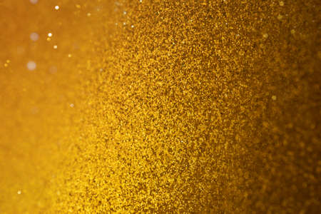 golden paillettes, that have a shape of bokeh blur, are gradually shifting into same, but softened particles                        の写真素材