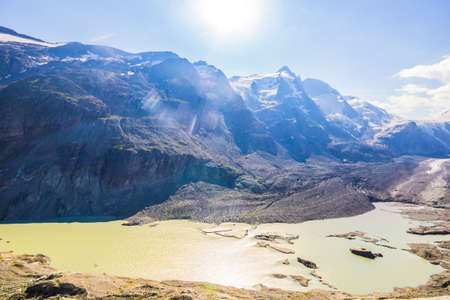 Sunrays over the Grossglockner Mountain Group and Pasterze, the longest Glacier of the Eastern Alps with a lake of Meltwaterの写真素材