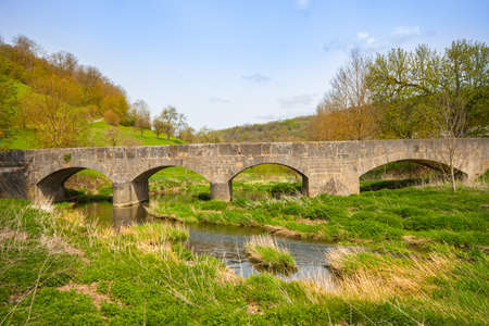 Stone bridge at Tauberscheckenbach in spring, on the Tauber River, Bavaria, South Germanyの写真素材