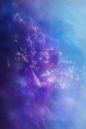 Young woman enjoyes the closeness to a beauty bush at springtime.の写真素材