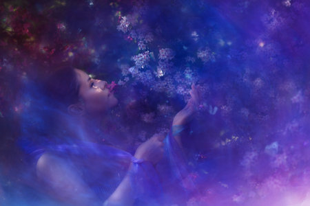 Enchanted springtime scene with a young woman, reaching out to a white butterfly.の写真素材