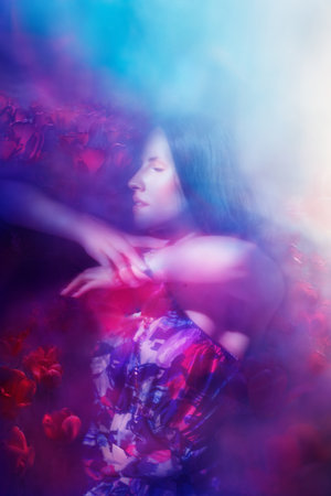 Emotional, tender young woman, feeling the affection and ardor of pink tulips.