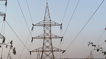 High-voltage power lines against the blue sky. Electricity distribution station.