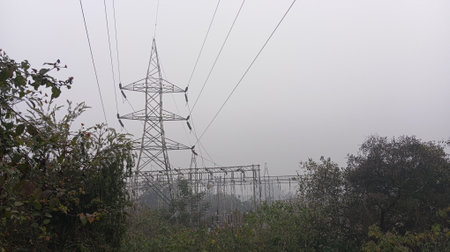 Power line in the fog. Electricity distribution station. Power transmission tower.