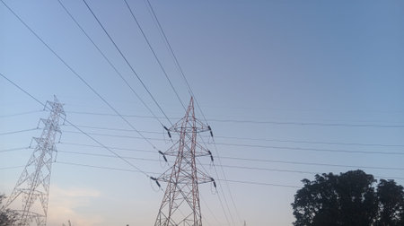 High voltage power lines against a clear blue sky. Electricity distribution station.