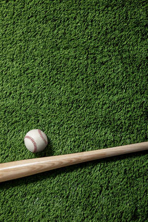 Overhead view of a baseball and bat on green artificial turfの写真素材