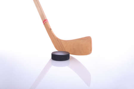 Hockey Stick And Puck On Reflective Surface With A White