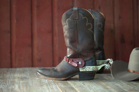 Cowboy boots with spurs and a hat on an old wood の写真素材