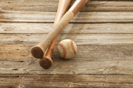 An old baseball and wooden bats on a rough wood surfaceの写真素材