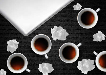 Crumpled colorful papers with laptop and coffee on black desktop.の写真素材