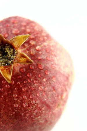 Ripe pomegranate fruit with water drops  isolated on white background .