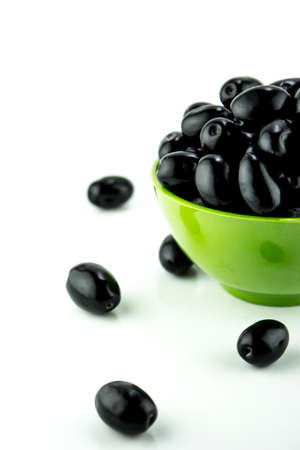 Black Olives in green bowl on a white backgroundの写真素材