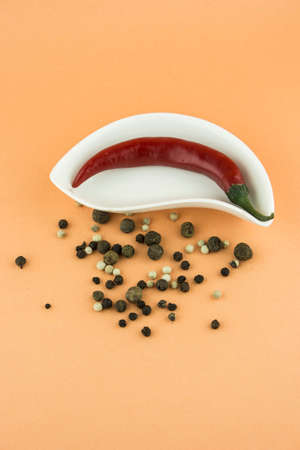 red hot chili pepper in plate on orange backgroundの写真素材