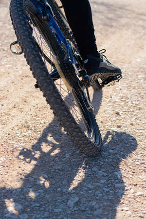 Mountain bike ride on a stone road. Close-up of the rear wheel.