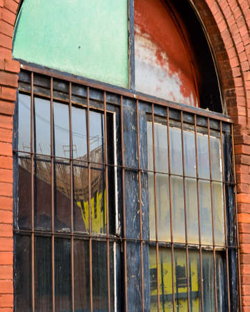 New Bricktown Construction Project Reflected in and Old Brick Building with Rusted Bars in Oklahoma City, Oklahomaのeditorial素材