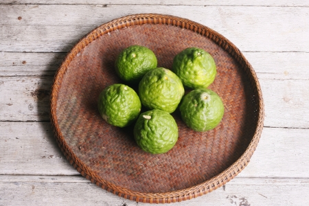Bergamots in the threshing basket on wooden tableの写真素材