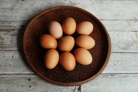 eggs  in threshing basket on wooden tableの写真素材