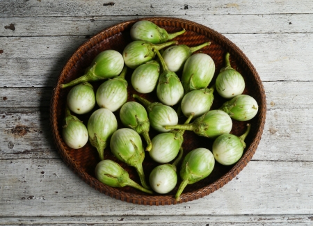 green eggplants  Cockroach Berry  in the threshing basket on wooden tableの写真素材