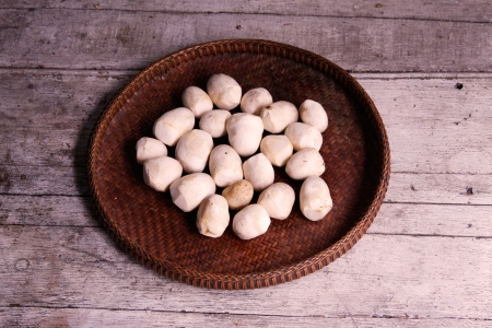 Fresh straw mushrooms in the threshing basket on wooden tableの写真素材