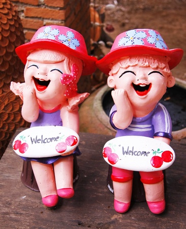 two smile girls baked clay dolls ornamental in the gardenの写真素材
