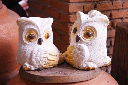 two owls baked clay ornamental in the gardenの写真素材
