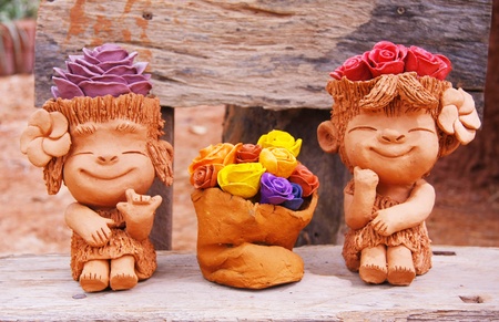 two pretty girls baked clay dolls ornamental in the gardenの写真素材