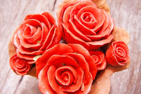 beautiful red roses baked clay on wooden tableの写真素材