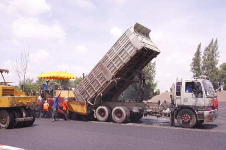 LOP BURI,THAILAND - AUGUST 3  Workers operating asphalt paver machine and heavy machinery during repairs road under the  program repairs road in asphalt plant on August 3,2013 in Lop Buri,Thailand のeditorial素材