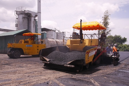 LOP BURI,THAILAND - AUGUST 3  Workers operating asphalt paver machine and heavy machinery during repairs road under the  program repairs road in asphalt plant on August 3,2013 in Lop Buri,Thailand のeditorial素材