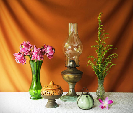 still life with vase,lotus,lamp,brass tray with pedestal,earthen bowl and orchid の写真素材