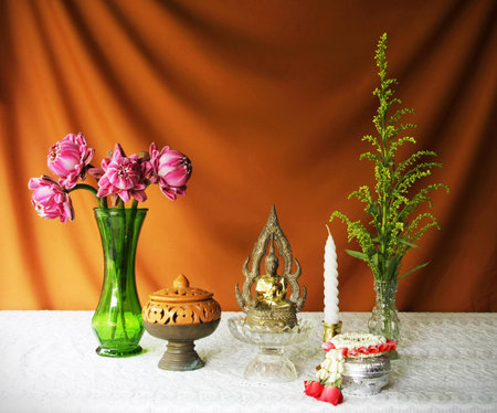 still life with buddha statue,vase,lotus,brass tray with pedestal,earthen bowl,garland and candle の写真素材