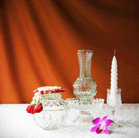 glass bowl, vase, orchid, glass tray with pedestal ,candle and jasmine garland の写真素材