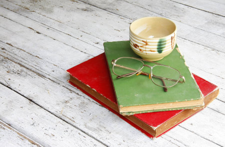 still life with old book,glasses,tea cup on wooden table  の写真素材