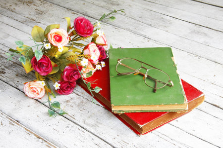 Still life with a beautiful classical bouquet of roses,glasses and old book  の写真素材