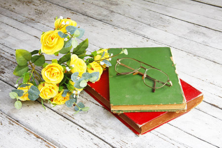 Still life with a beautiful classical bouquet of roses,glasses and old book  
