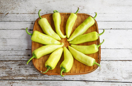 still life with Green peppers in the threshing basket on wooden table の写真素材