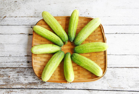 still life with Cucumbers in the threshing basket on wooden table の写真素材